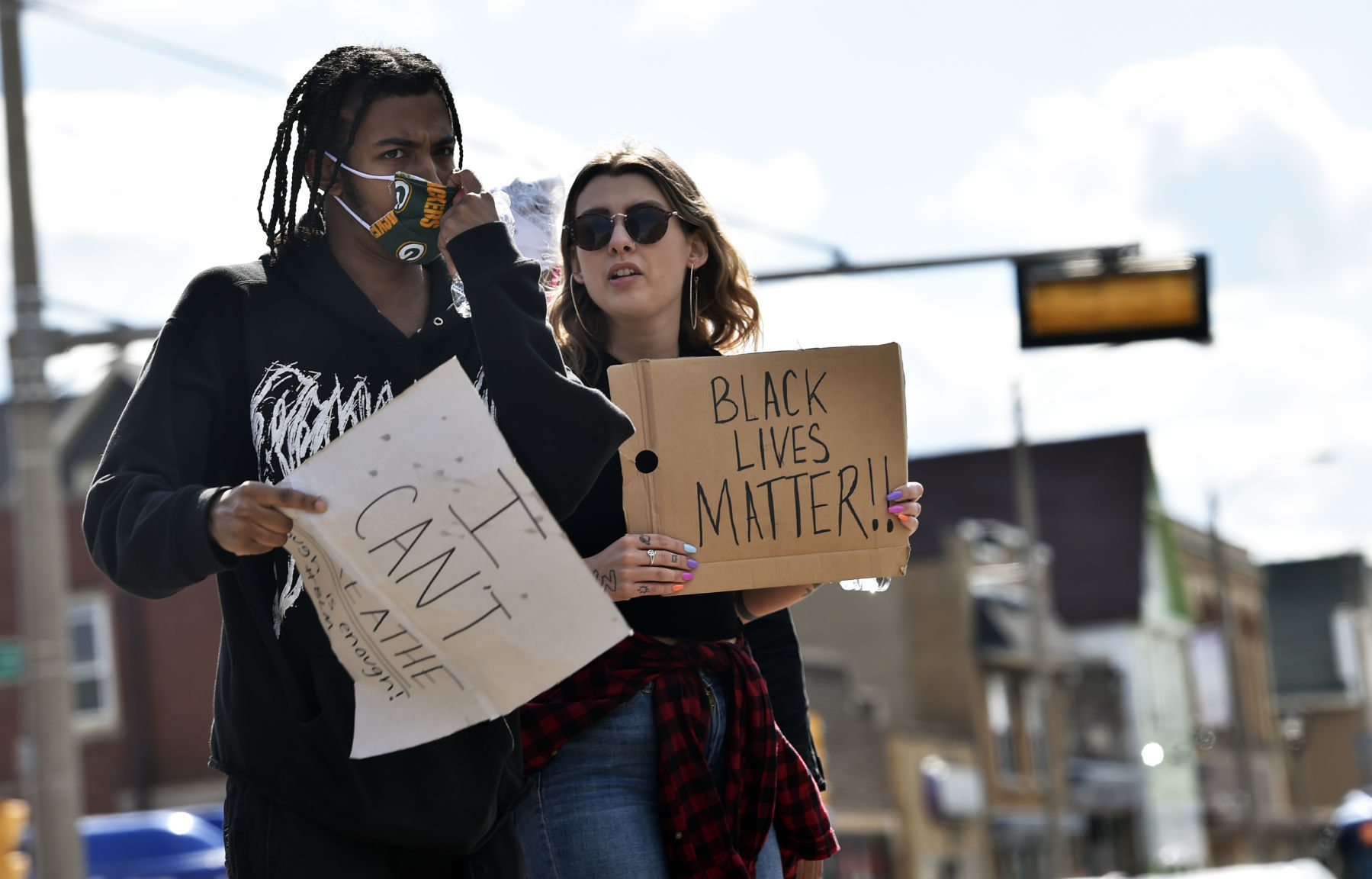 I can't breathe sign held by man in a Packer mask